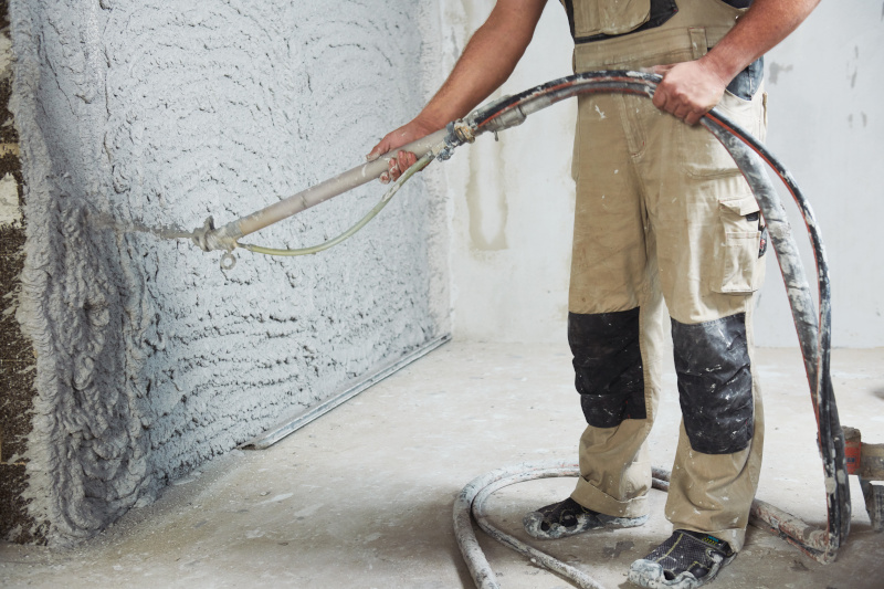 Bauarbeiter verputzt eine Wand im Haus